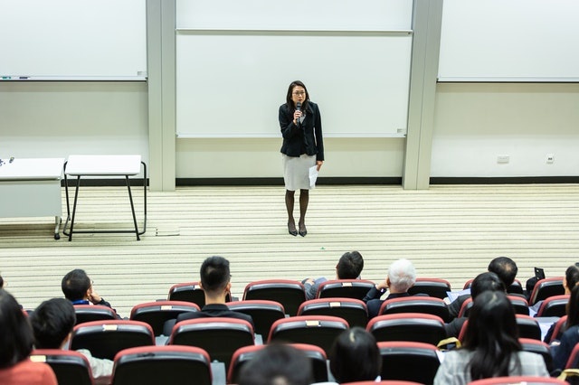 student lecturer at front of hall